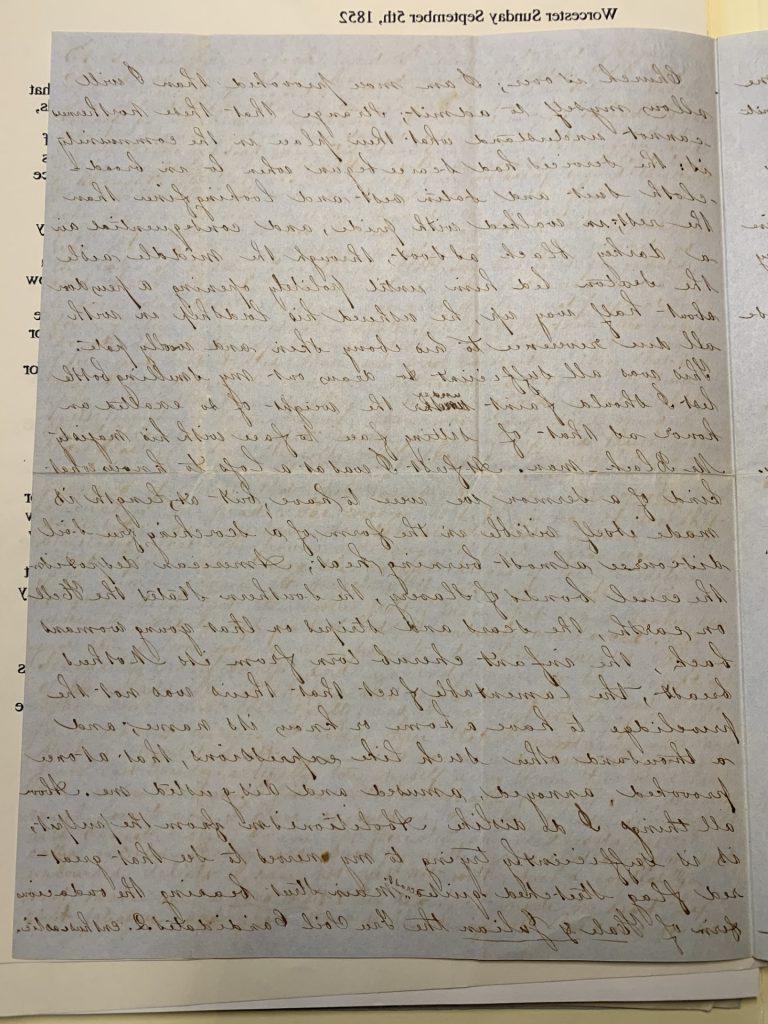 Color photograph of a black ink handwritten letter on paper discolored with age. 